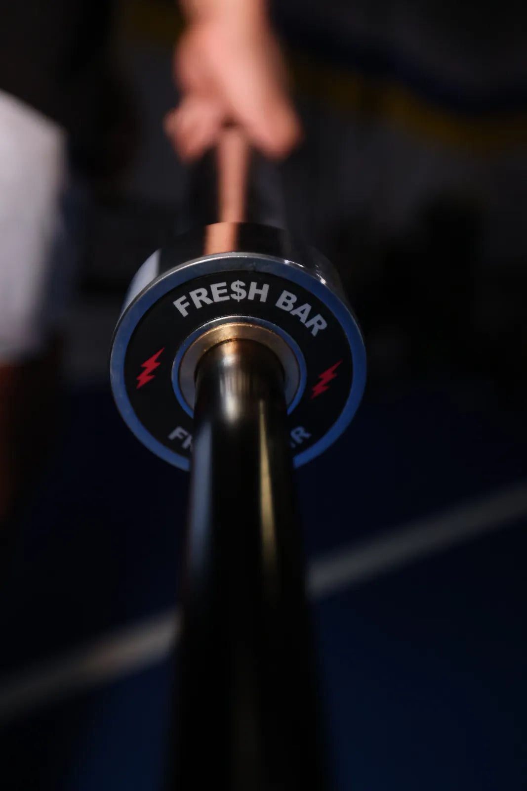 Fresh Bar: A hand holding the Fresh Bar by its loadable end on blue turf.