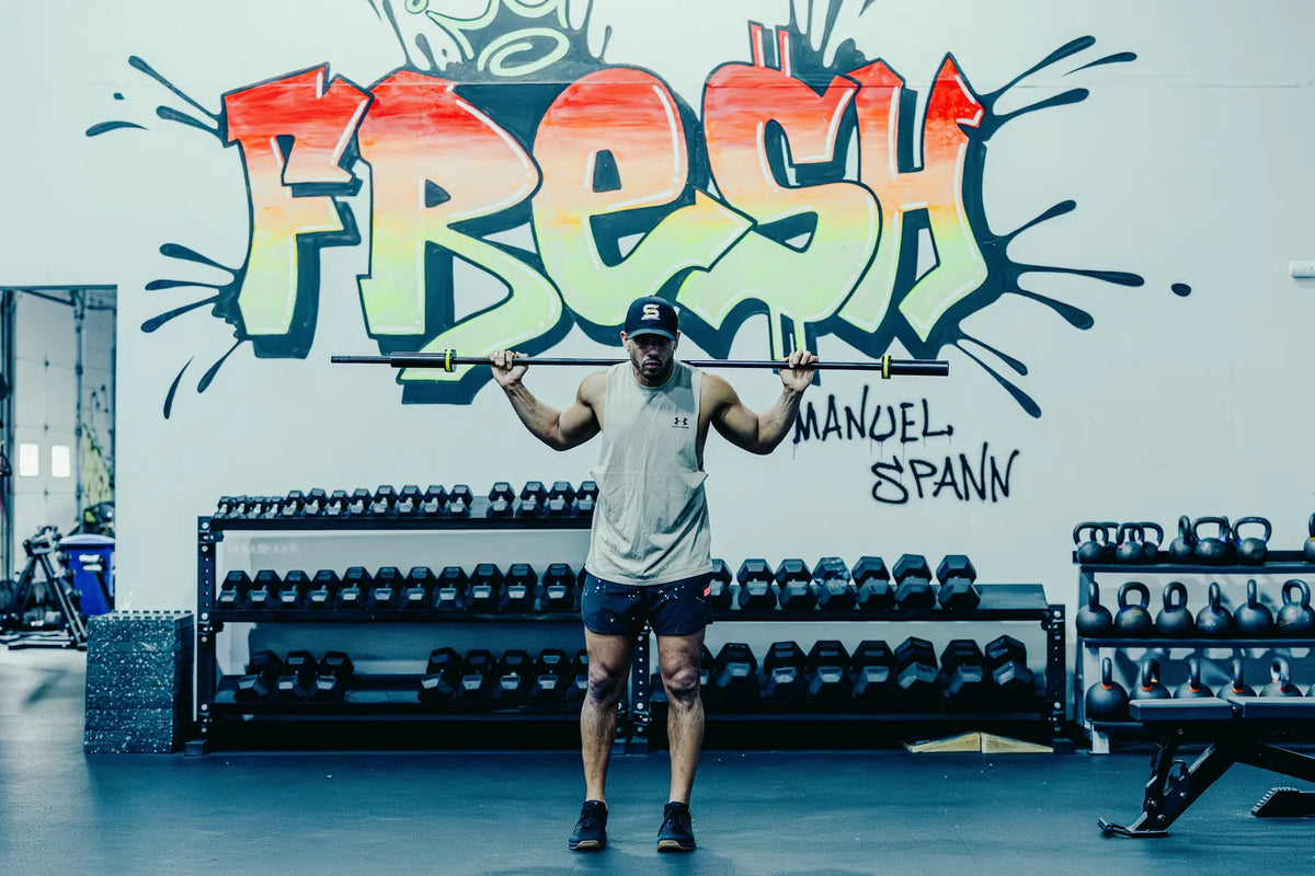 Melo Bar: An athlete with the Melo Bar across his shoulders in front of the FRESH mural.