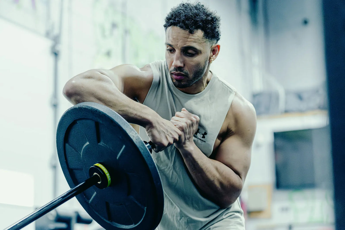 Melo Bar: An athlete holding the loaded Melo Bar at his chest in the gym.
