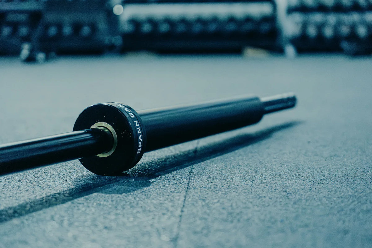 Spann Bar: The Spann Bar on the gym floor, its black SPANN BAR collar toward the camera.