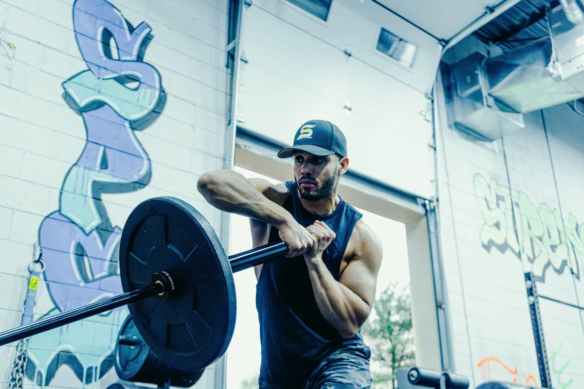 Spann Bar: An athlete pressing the loaded Spann Bar from his chest, the black collar beside the plate.