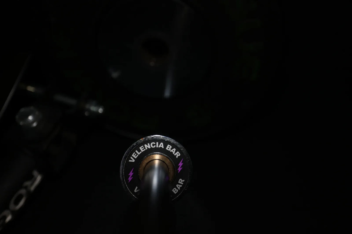 Velencia Bar: The Velencia Bar end cap, purple bolts, in the rack beside a Rogue plate.